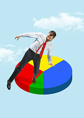 Image showing Businessman balancing on a pie chart