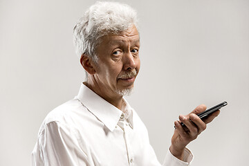 Image showing Indoor portrait of senior man holding blank smartphone