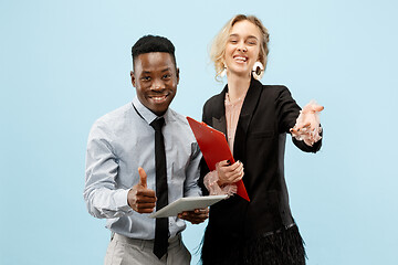 Image showing Concept of partnership in business. Young man and woman standing at studio