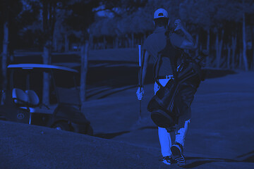 Image showing golfer  walking and carrying golf  bag