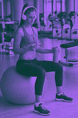 Image showing woman with headphones in fitness gym