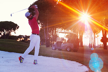 Image showing golfer hitting a sand bunker shot on sunset