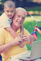 Image showing grandfather and child using laptop