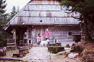 Image showing frineds together in front of old wooden house