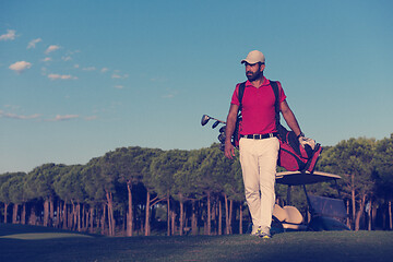 Image showing golfer  walking and carrying golf  bag