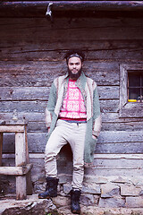 Image showing portrait of young hipster in front of wooden house