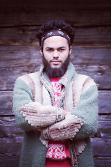 Image showing portrait of young hipster in front of wooden house