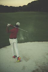 Image showing golfer hitting a sand bunker shot on sunset