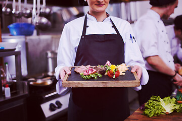 Image showing female Chef holding beef steak plate