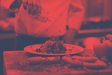 Image showing Chef finishing steak meat plate