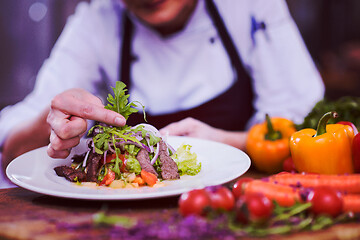 Image showing cook chef decorating garnishing prepared meal