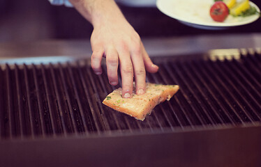 Image showing chef hands cooking grilled salmon fish