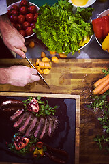 Image showing top view of Chef hands serving beef steak