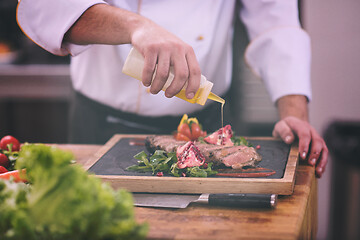 Image showing Chef finishing steak meat plate