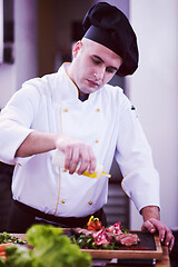 Image showing Chef finishing steak meat plate