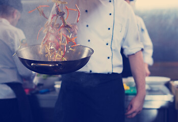 Image showing chef flipping vegetables in wok