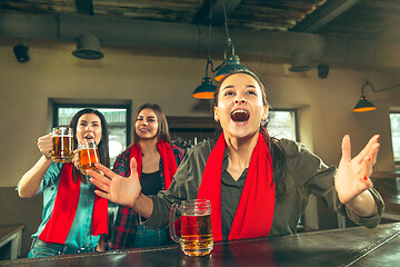 Image showing Sport, people, leisure, friendship and entertainment concept - happy football fans or female friends drinking beer and celebrating victory at bar or pub