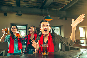 Image showing Sport, people, leisure, friendship and entertainment concept - happy football fans or female friends drinking beer and celebrating victory at bar or pub