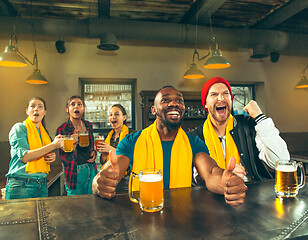 Image showing Sport, people, leisure, friendship and entertainment concept - happy football fans or male friends drinking beer and celebrating victory at bar or pub