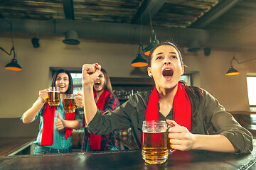 Image showing Sport, people, leisure, friendship and entertainment concept - happy football fans or female friends drinking beer and celebrating victory at bar or pub