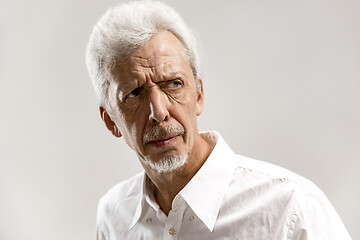 Image showing The serious businessman standing and looking at camera against gray background.