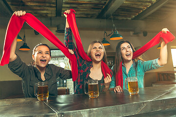 Image showing Sport, people, leisure, friendship and entertainment concept - happy football fans or female friends drinking beer and celebrating victory at bar or pub