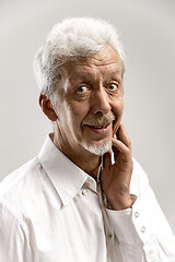 Image showing The happy senior business man standing and smiling against gray background.