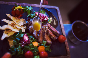 Image showing Chef hand finishing steak meat plate