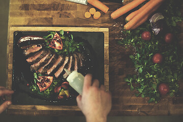 Image showing top view of Chef finishing steak meat plate