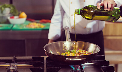 Image showing chef flipping vegetables in wok