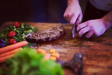 Image showing closeup of Chef hands preparing beef steak