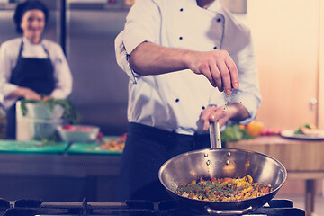 Image showing chef putting spices on vegetables in wok