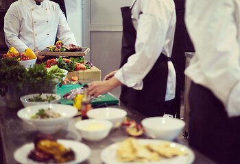 Image showing team cooks and chefs preparing meal