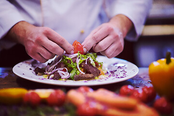 Image showing cook chef decorating garnishing prepared meal