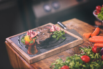 Image showing Juicy slices of grilled steak on wooden board