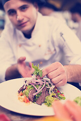 Image showing cook chef decorating garnishing prepared meal