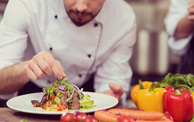 Image showing cook chef decorating garnishing prepared meal