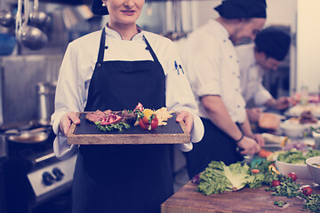 Image showing female Chef holding beef steak plate