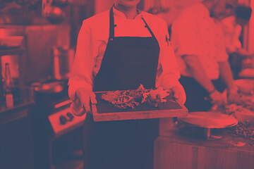 Image showing female Chef holding beef steak plate