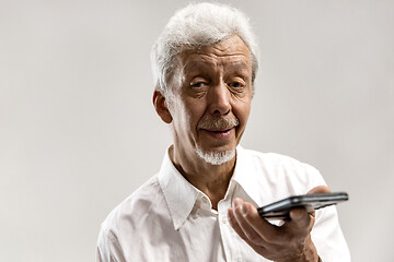 Image showing Indoor portrait of senior man holding blank smartphone