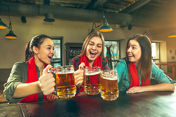 Image showing Sport, people, leisure, friendship and entertainment concept - happy football fans or female friends drinking beer and celebrating victory at bar or pub