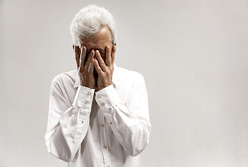 Image showing Portrait of upset old man rubbing his eye while crying.