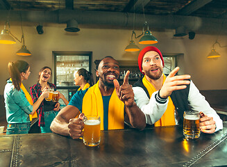 Image showing Sport, people, leisure, friendship and entertainment concept - happy football fans or male friends drinking beer and celebrating victory at bar or pub