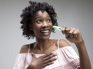 Image showing Smiling young woman looking on pregnancy test