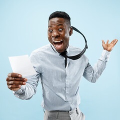 Image showing Young boy with a surprised expression won a bet on blue background