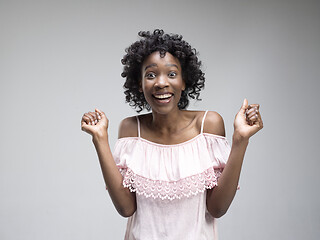 Image showing Winning success woman happy ecstatic celebrating being a winner. Dynamic energetic image of female afro model