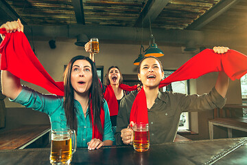 Image showing Sport, people, leisure, friendship and entertainment concept - happy football fans or female friends drinking beer and celebrating victory at bar or pub