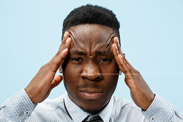 Image showing Man having headache. Isolated over blue background.