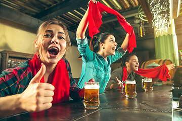 Image showing Sport, people, leisure, friendship and entertainment concept - happy football fans or female friends drinking beer and celebrating victory at bar or pub