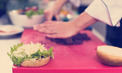 Image showing chef hands cutting salad for burger